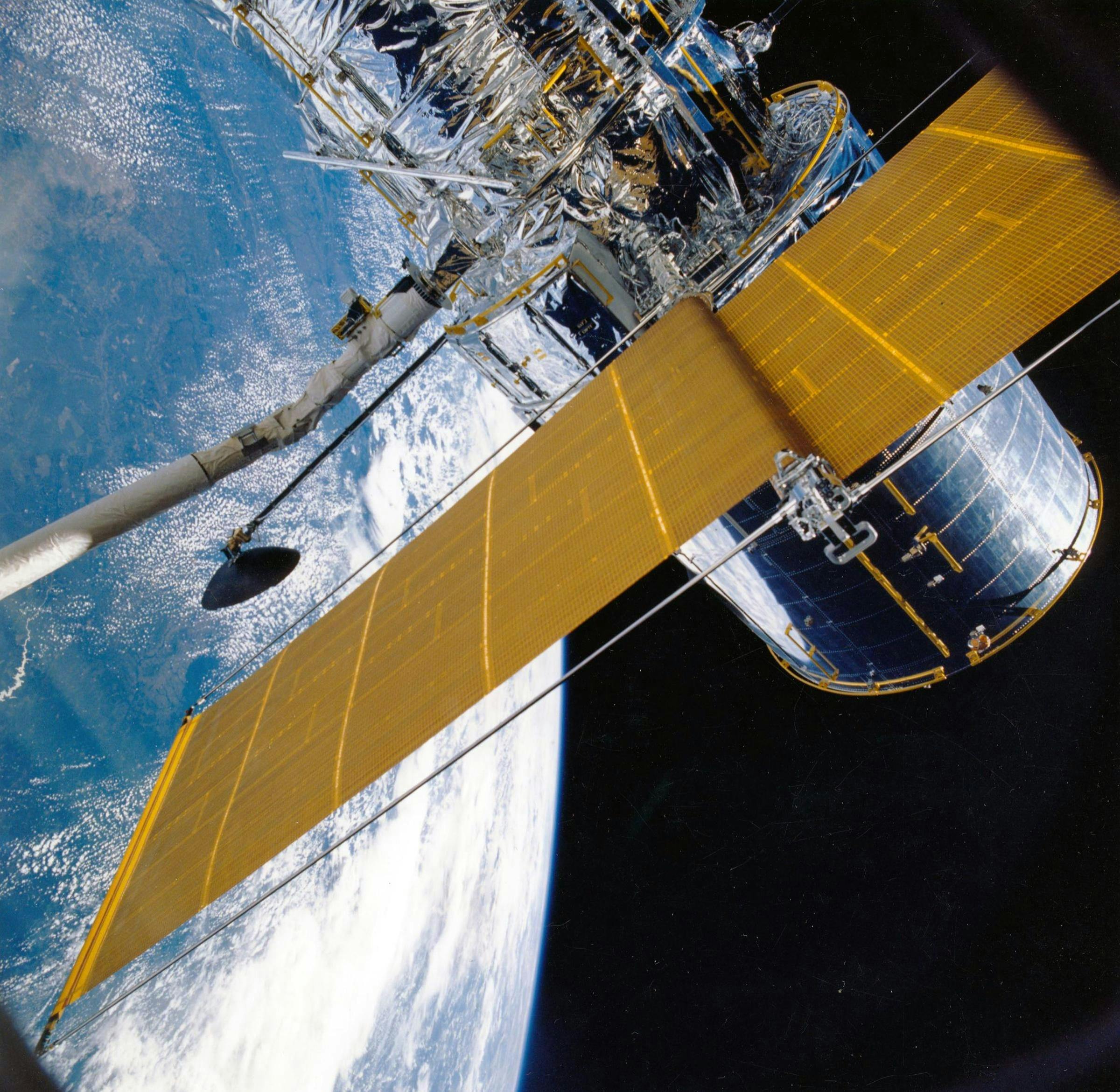 Spacecraft with solar panels orbiting Earth, showcasing modern astronautic technology.