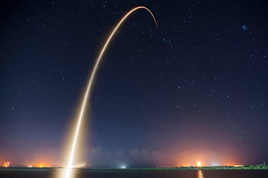 Spectacular long exposure of a rocket launch under a clear, starry night sky showcasing the trail.