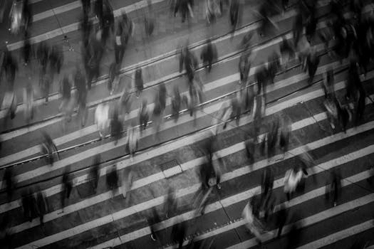 Blurred pedestrians crossing a busy Hong Kong street, showcasing urban movement and dynamics.